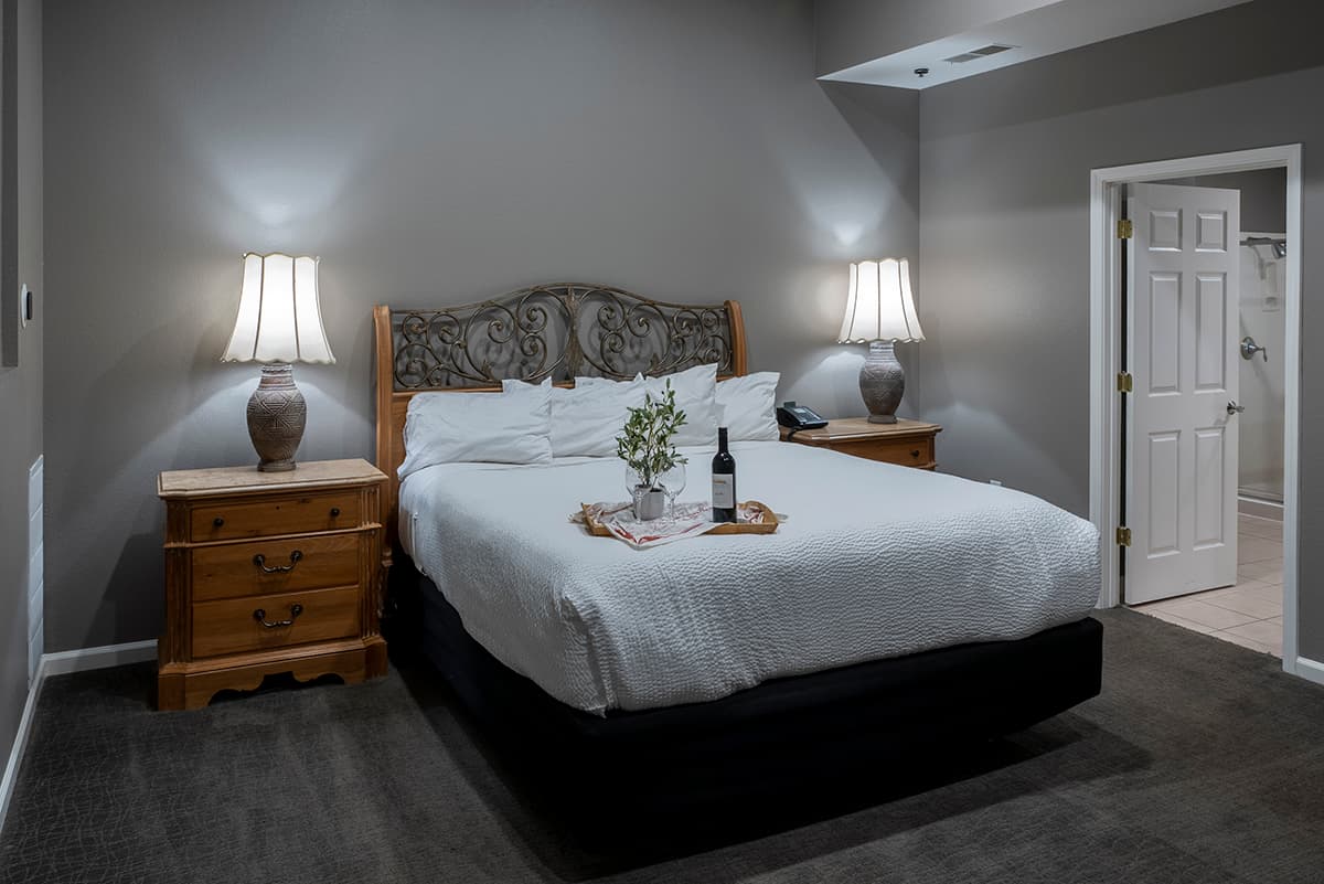 Cozy bedroom featuring a queen bed, nightstands, and soft lighting.