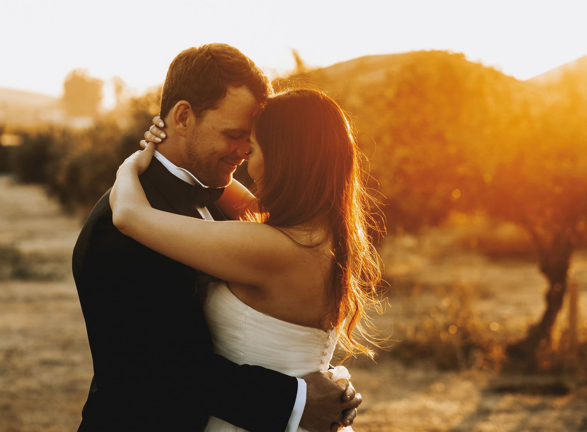 A couple embraces during a romantic sunset.